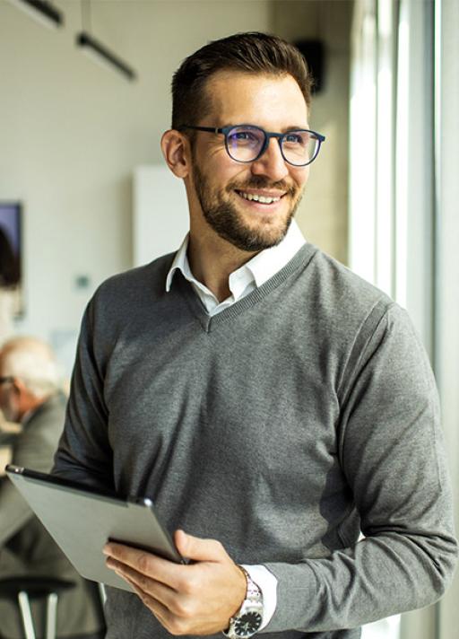 Un homme avec une tablette à la main sourit